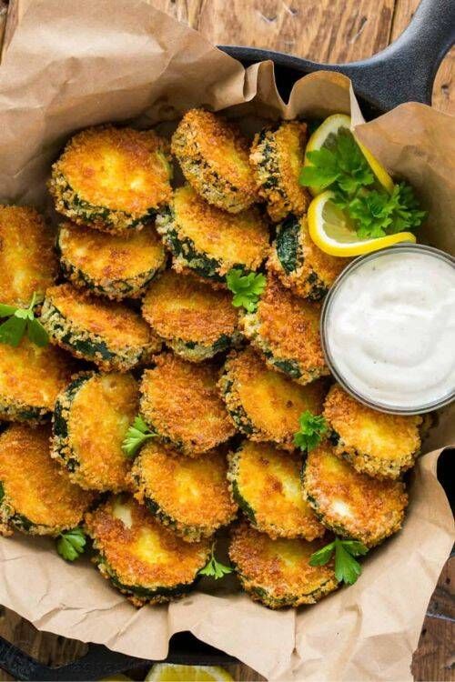 Golden fried zucchini rounds with a crispy batter and a side of creamy ranch dip
